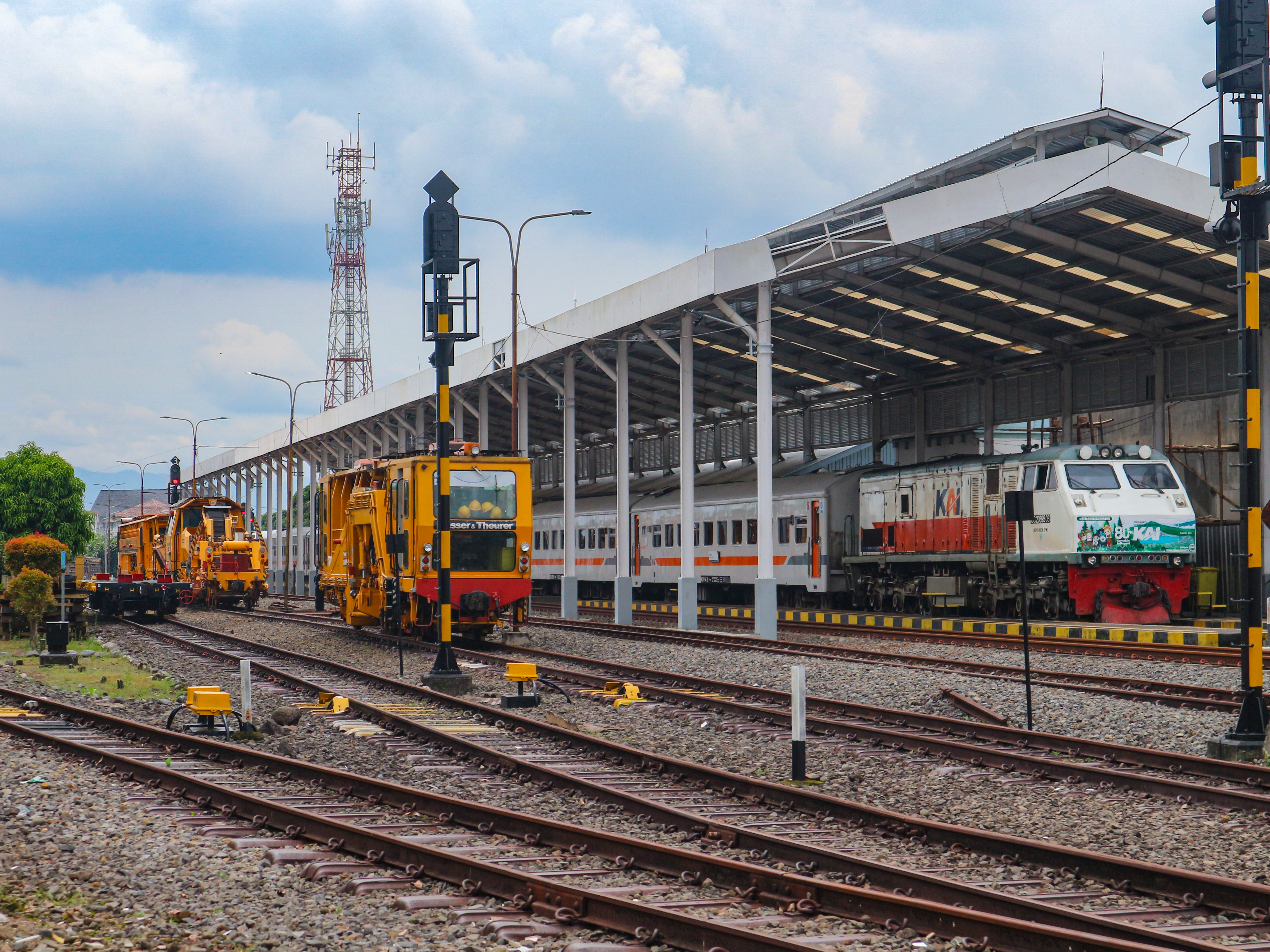 Kereta api Serayu Pagi berdampingan dengan sarana Plasser & Theurer di Stasiun Tasikmalaya