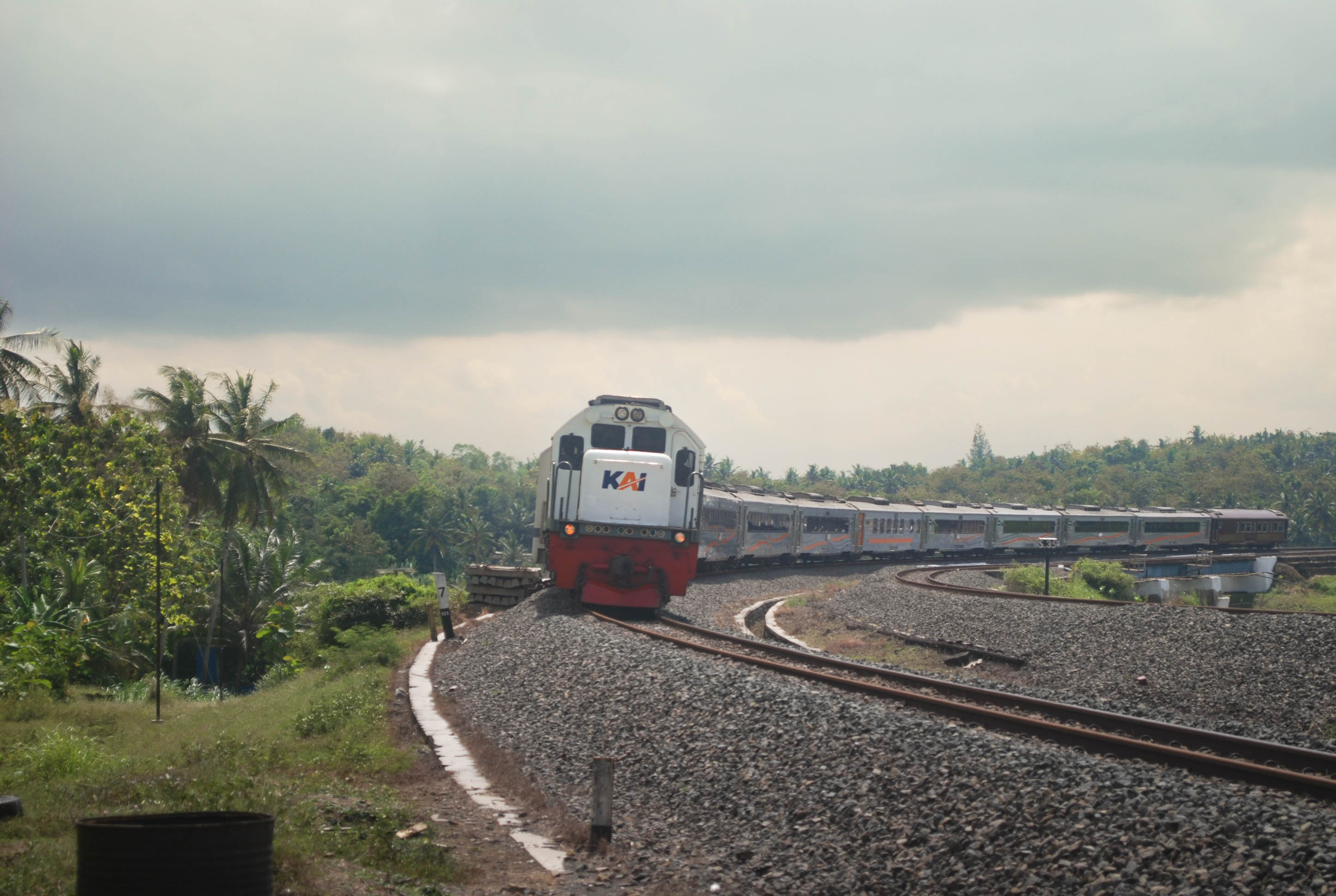 Kereta Api Manahan dengan backgorund pemandangan perbukitan di sekitar spot Kelok Mertan, Sentolo