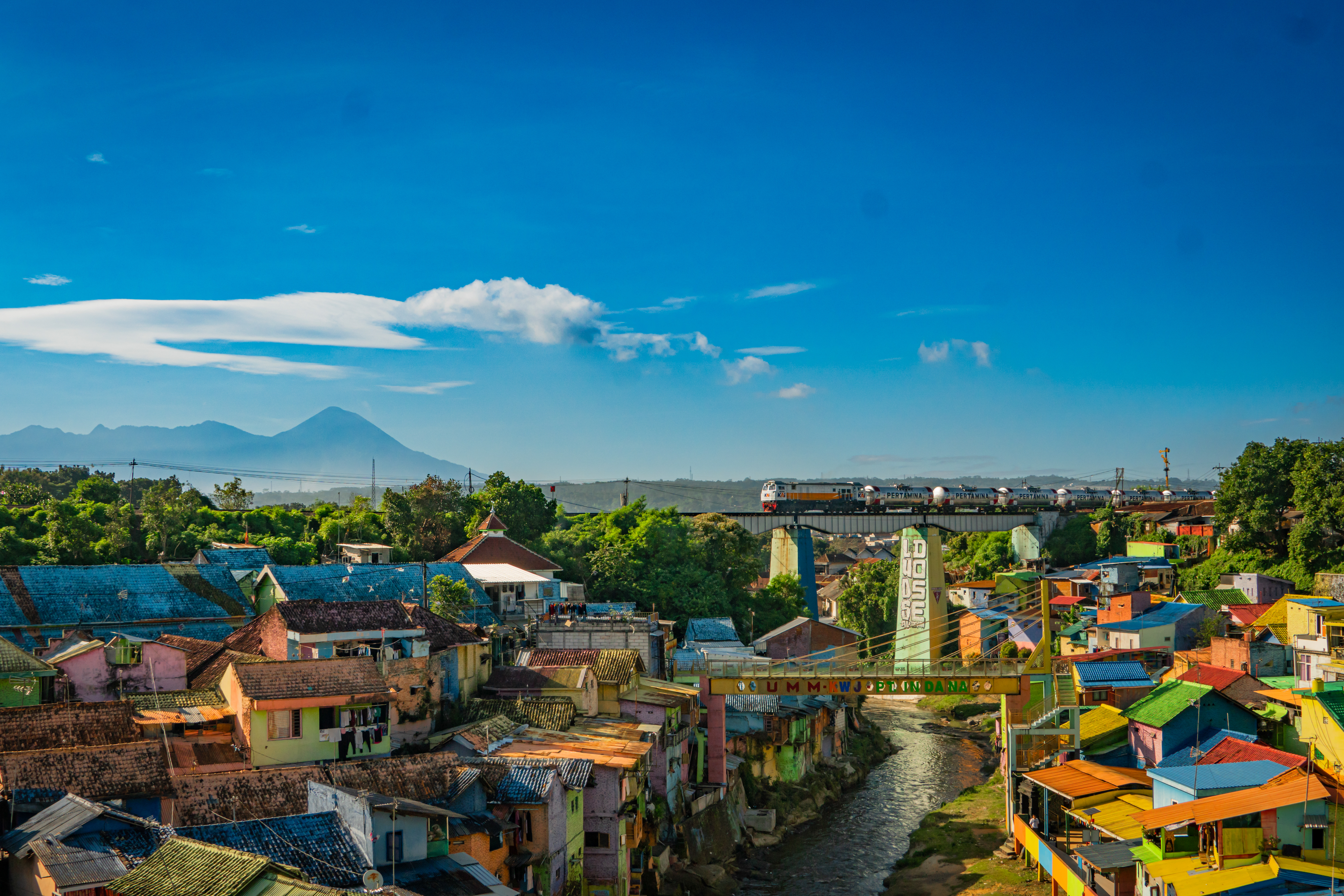 Rangkaian kereta akan mengambil ke kilang minyak Cilacap sedang melintas di Kampung Warna Warni Jodipan Malang