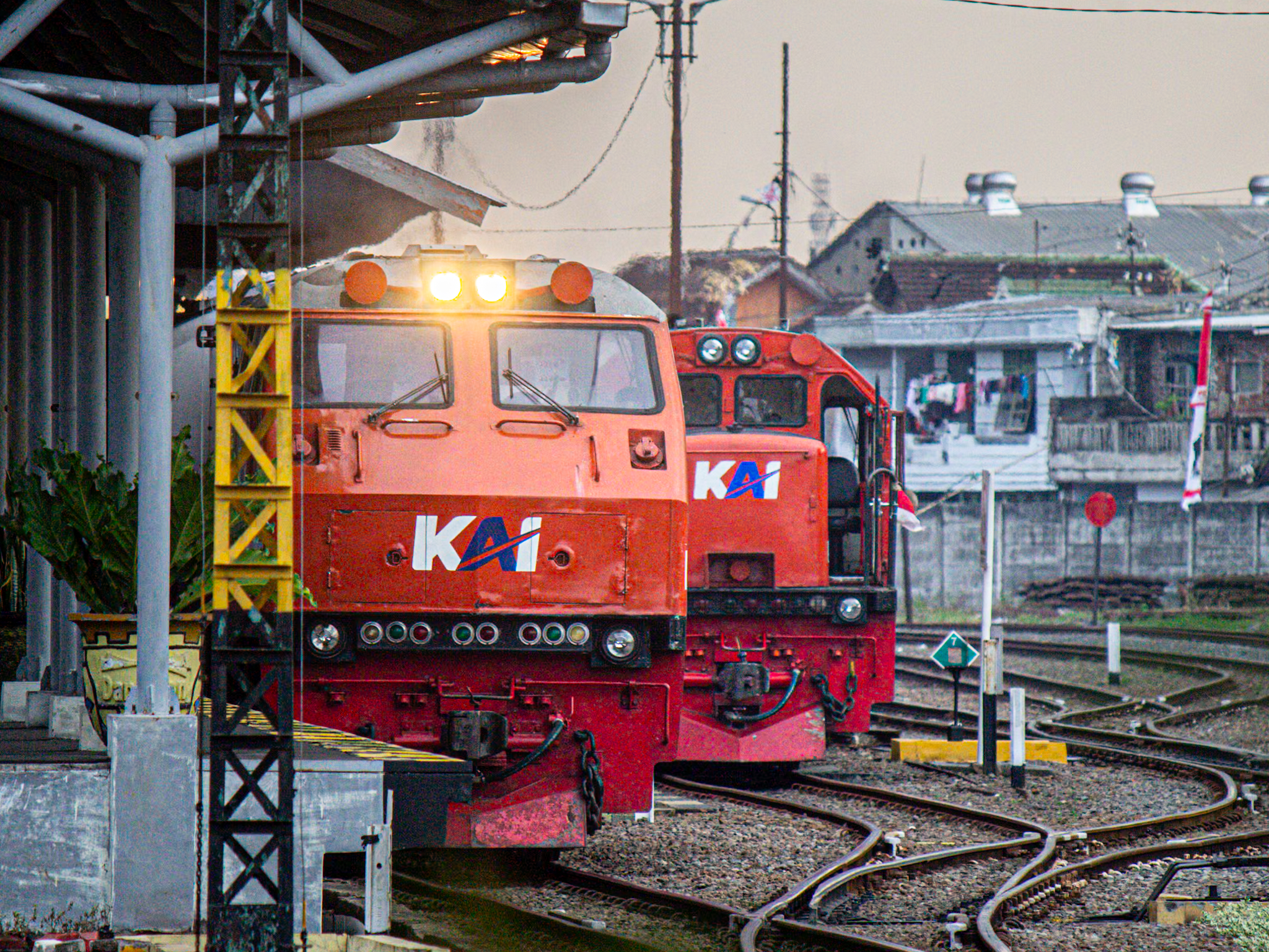 dua lokomotiv merah yang sedang berjejer di stasiun malang kota  lama