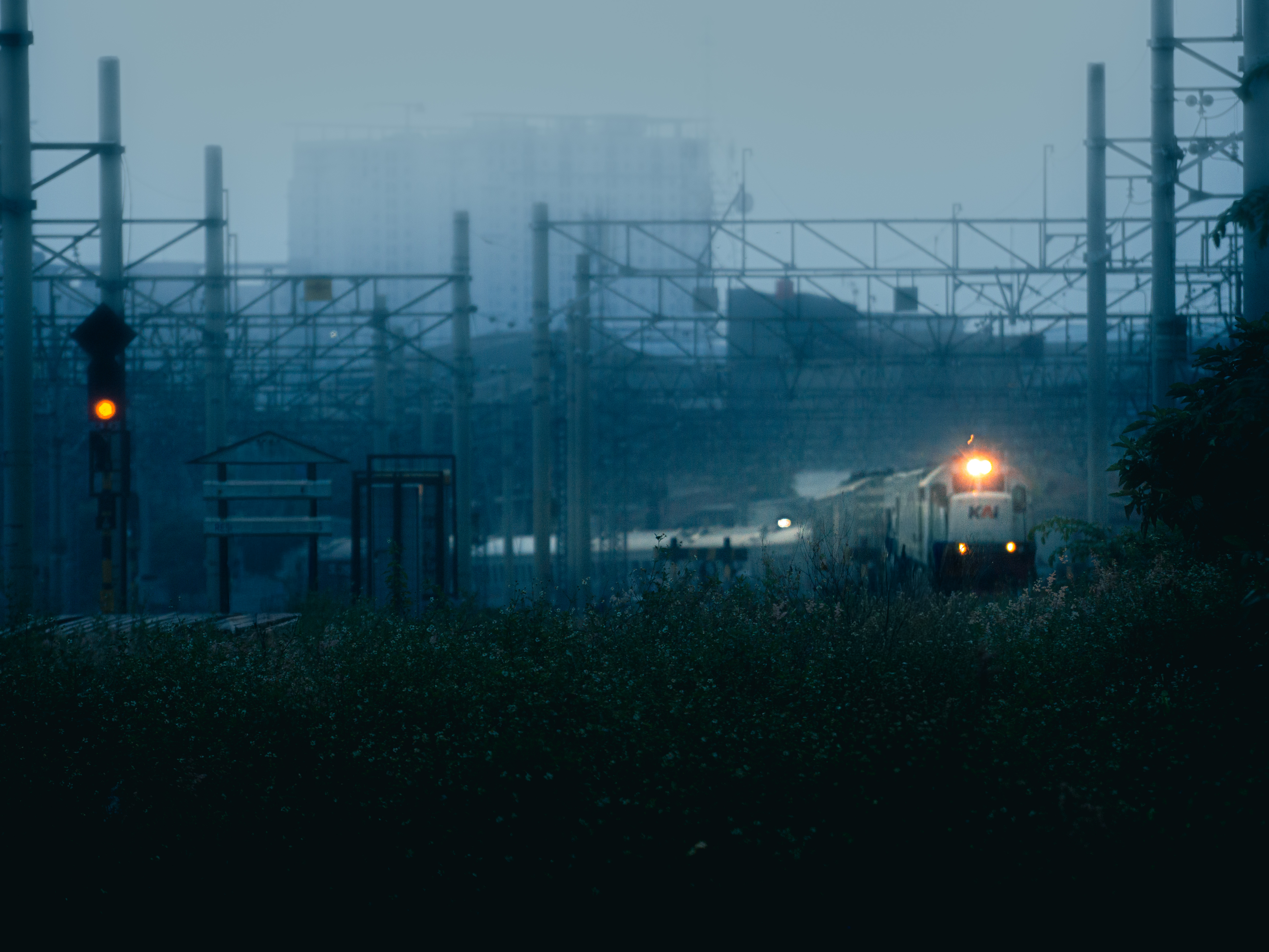 Sorot lampu menembus kabut, mengantar sore menuju malam.