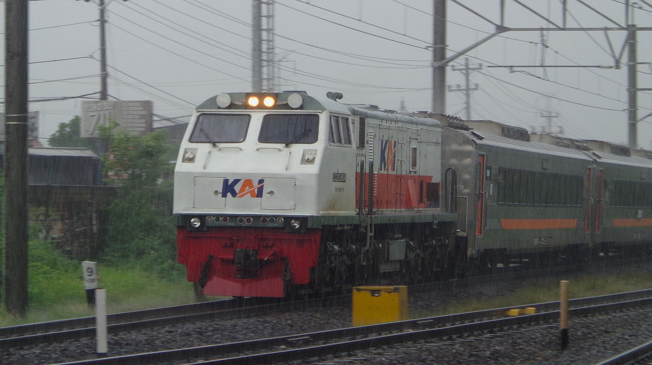 CC 203 98 04 menerjang hujan saat memasuki Stasiun Klaten